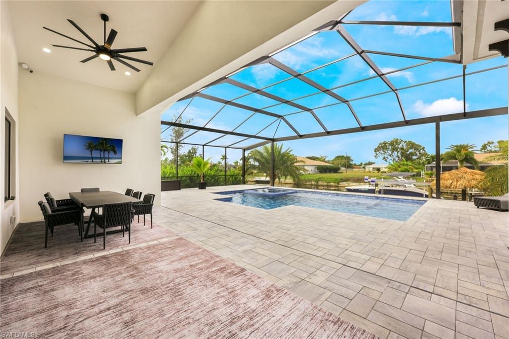 View of pool with a sunroom, a patio, ceiling fan, a lanai, and outdoor dining area