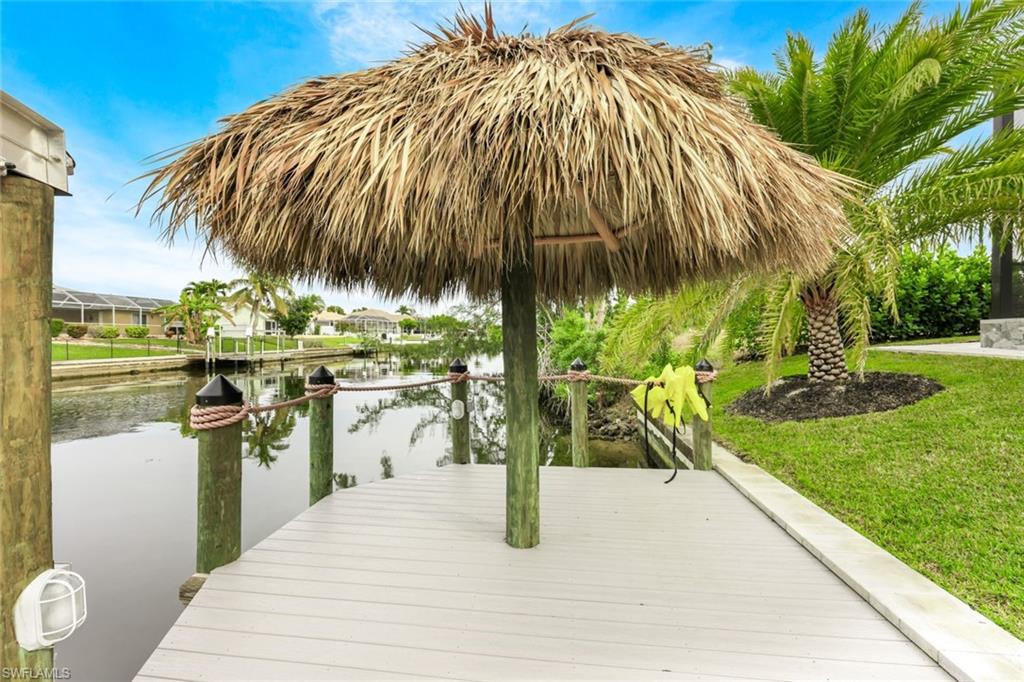 Dock area with a water view and a yard