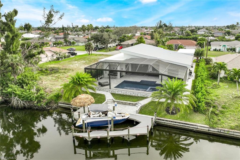 Dock area with an outdoor pool, glass enclosure, a residential view, an in-ground hot tub, and a patio area