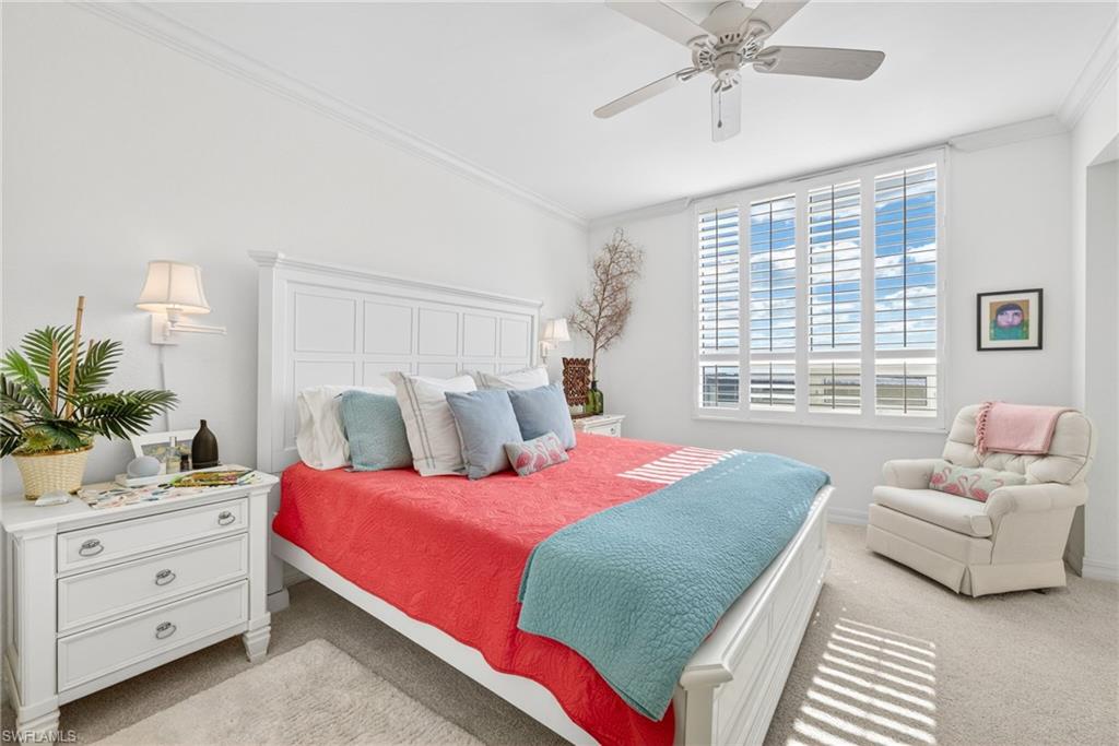 Bedroom with light colored carpet, a ceiling fan, and ornamental molding
