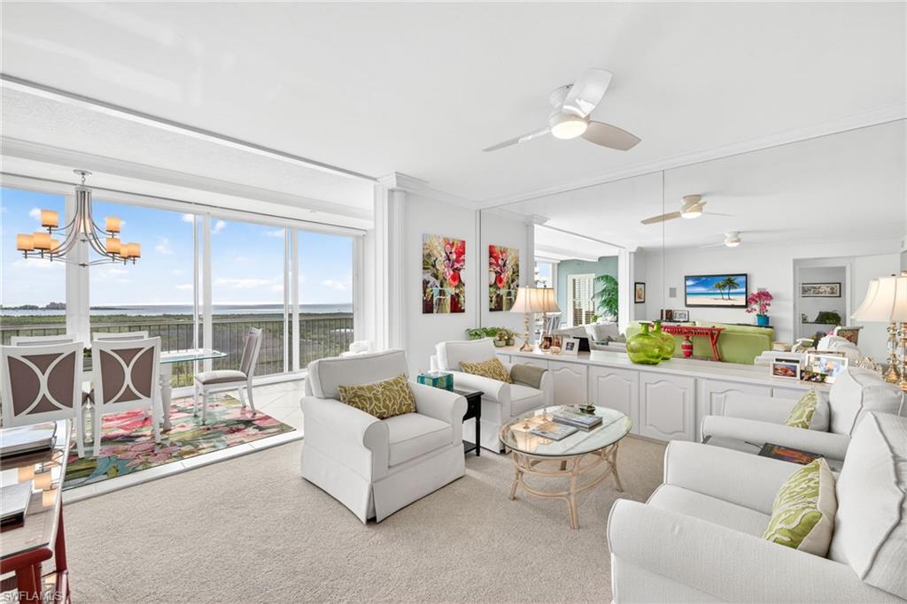 Carpeted living room with a chandelier and a ceiling fan