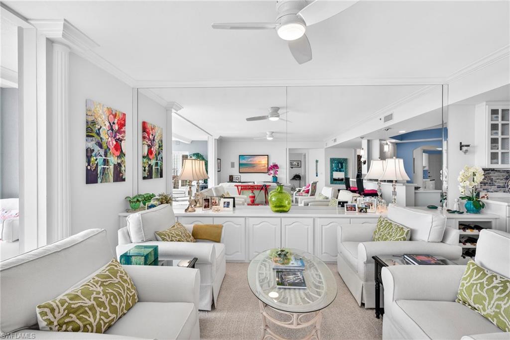 Living room featuring crown molding and a ceiling fan