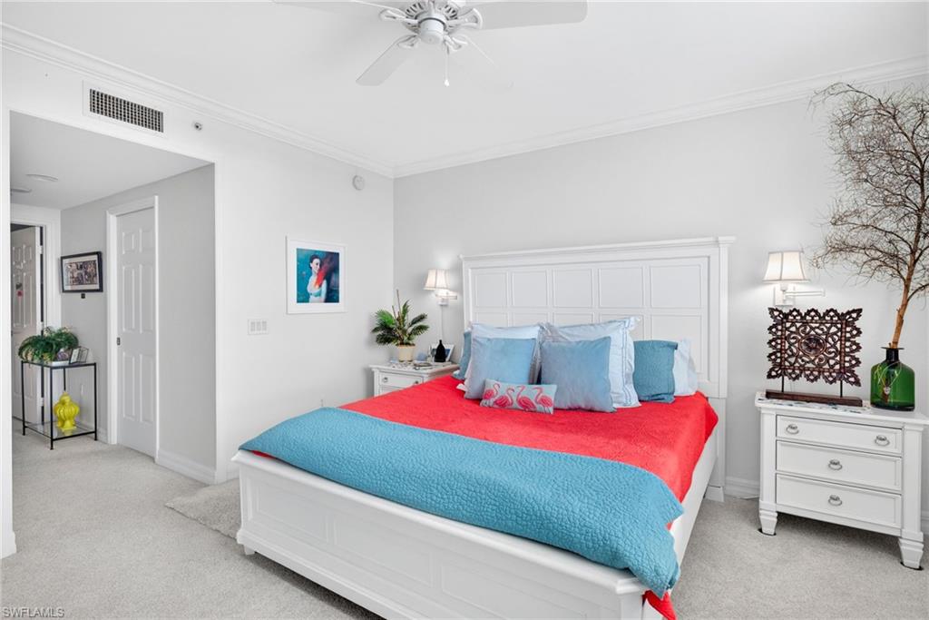 Bedroom with a ceiling fan, light carpet, and crown molding
