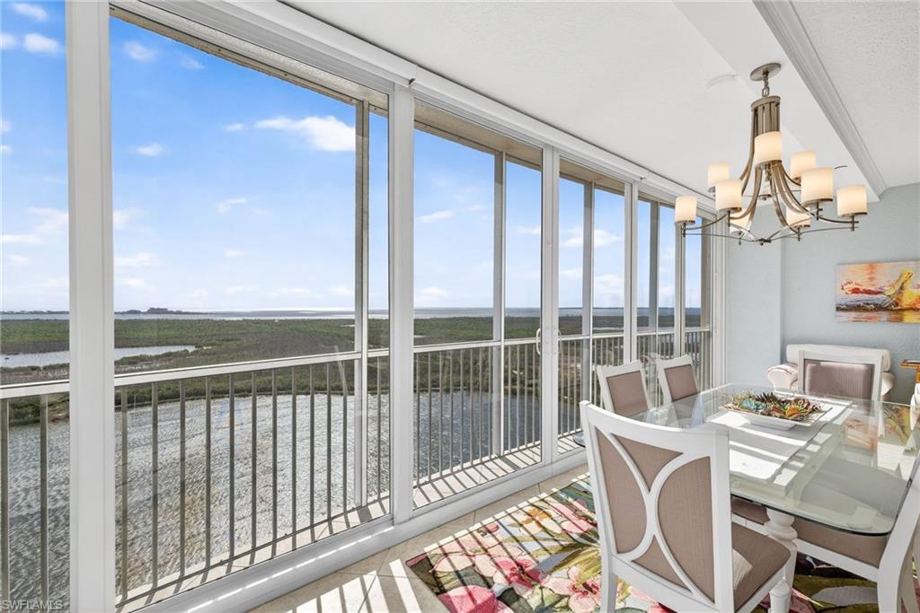 Sunroom / solarium featuring a chandelier and a water view