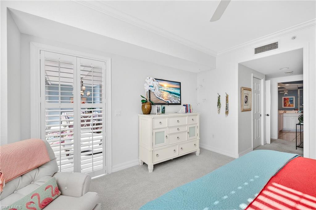 Carpeted bedroom with ornamental molding, ceiling fan, and access to outside