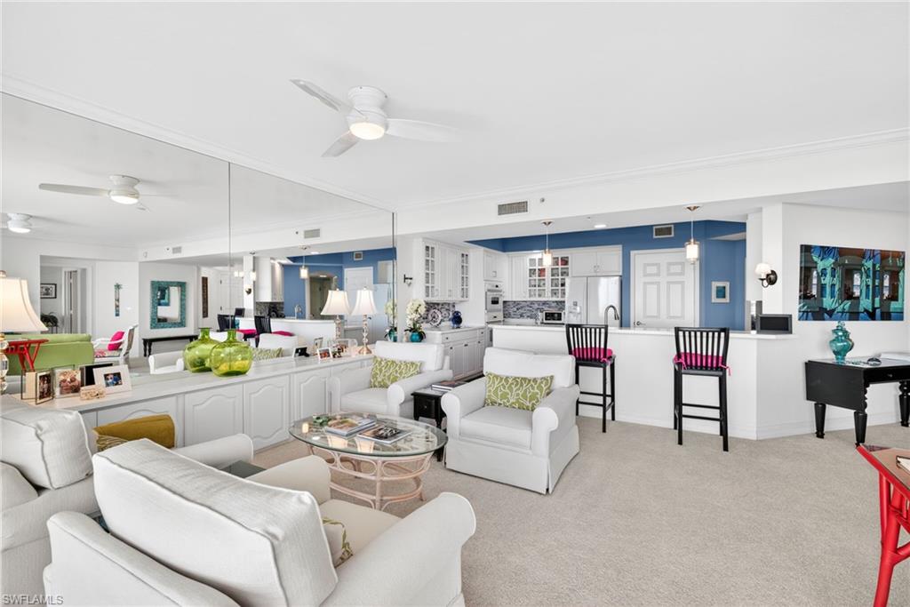 Living room featuring light carpet and a ceiling fan