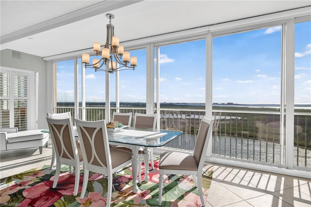 Sunroom with a water view and a chandelier
