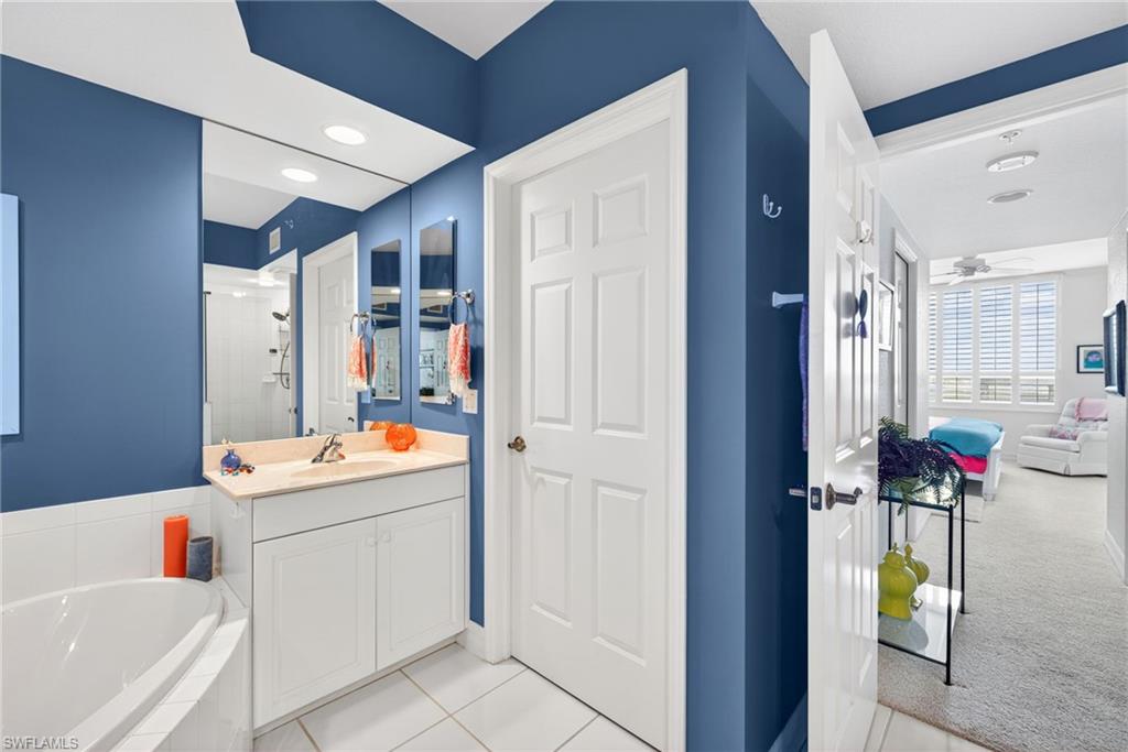 Full bathroom featuring a bath, vanity, light tile patterned floors, ceiling fan, and recessed lighting