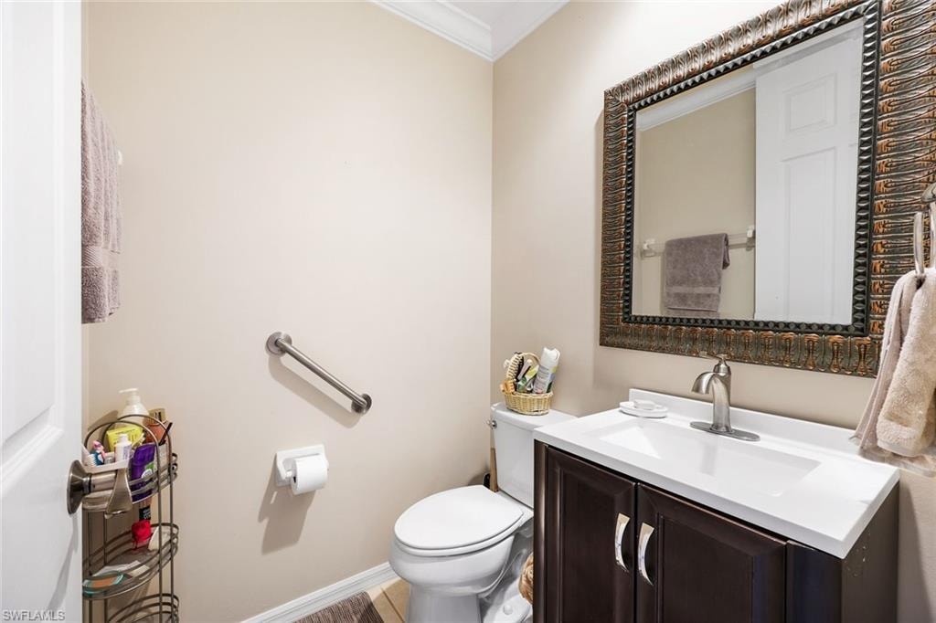 Half bath featuring vanity and crown molding