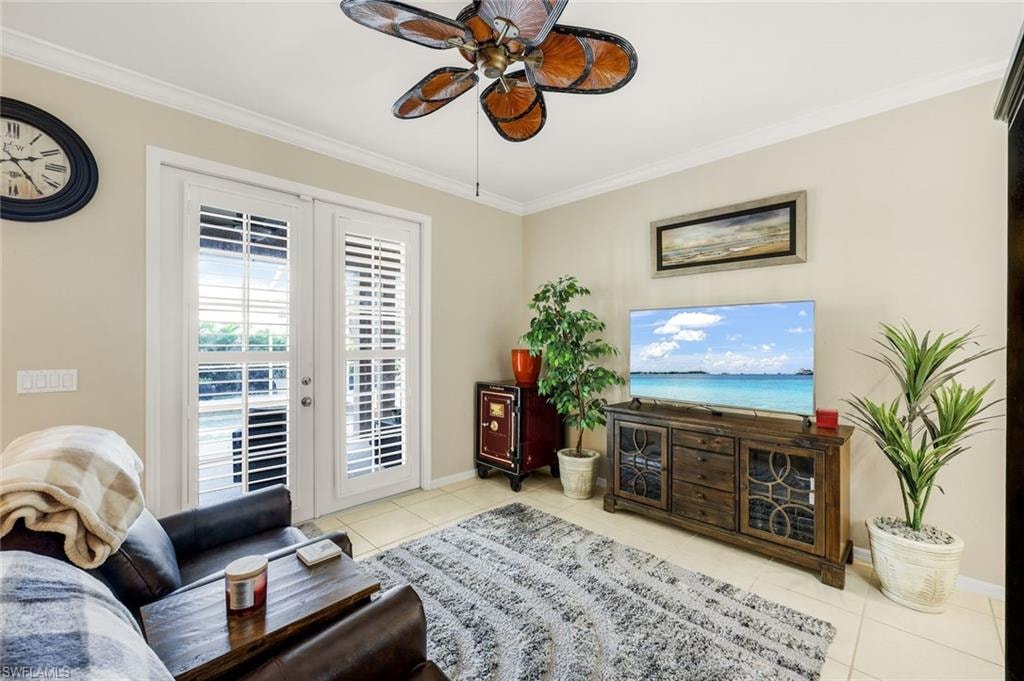 Living area featuring ornamental molding, light tile patterned floors, and a ceiling fan