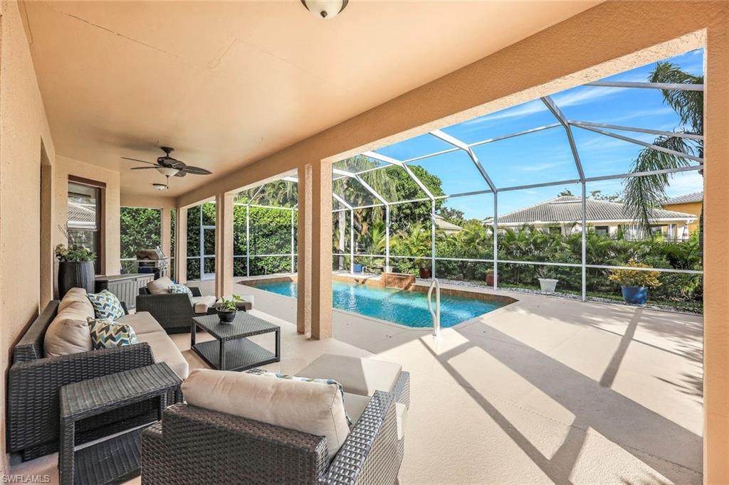 Outdoor pool with a patio area, a sunroom, outdoor lounge area, and glass enclosure