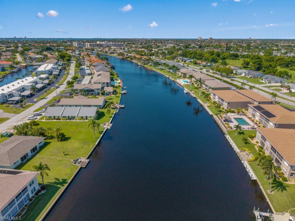 Aerial perspective of suburban area featuring a nearby body of water