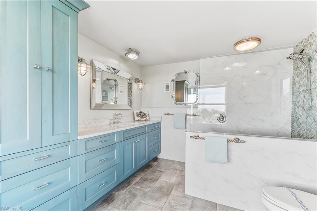 Full bathroom with vanity and a marble finish shower