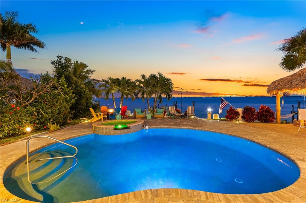 Pool at dusk with a patio and a pool with connected hot tub