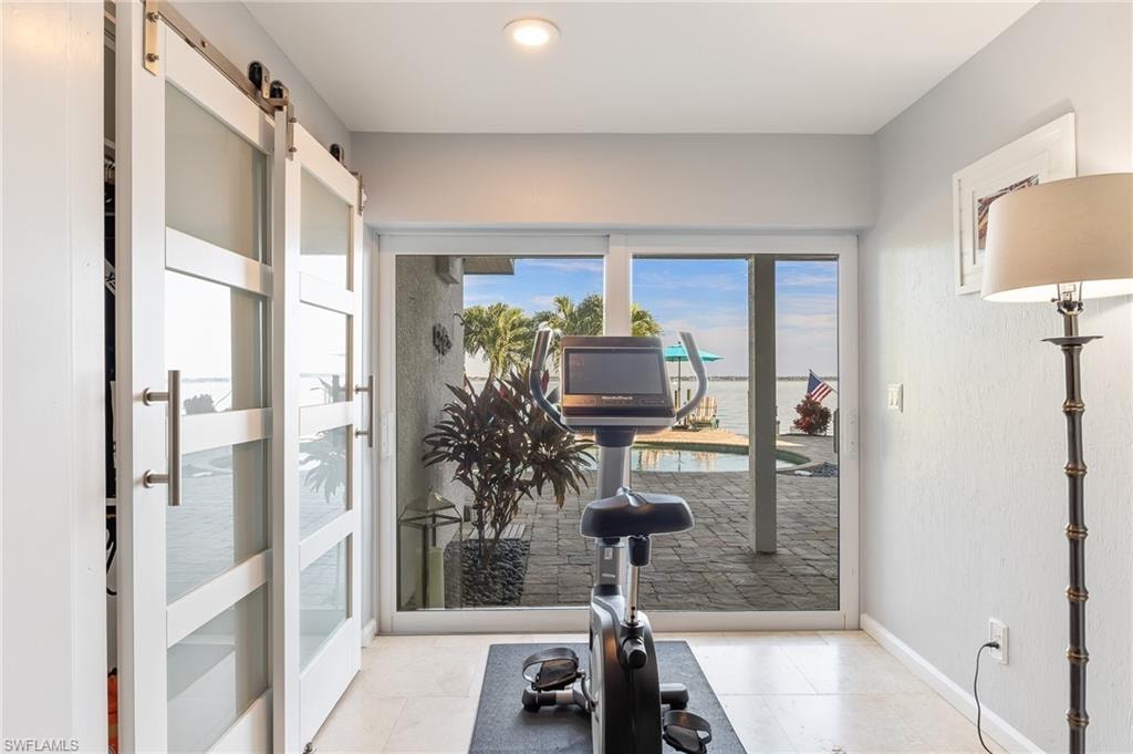 Exercise area with a barn door and light tile patterned floors