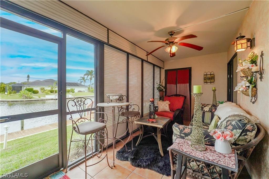 Sunroom / solarium featuring a water view and tile patterned floors