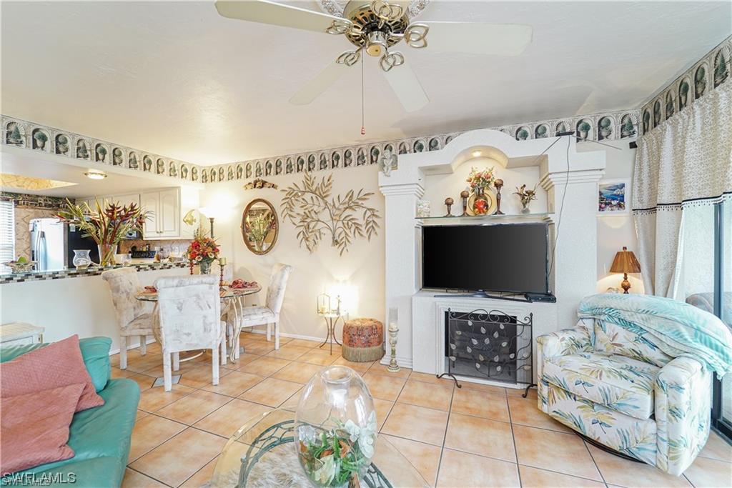 Living room with ceiling fan and light tile patterned floors