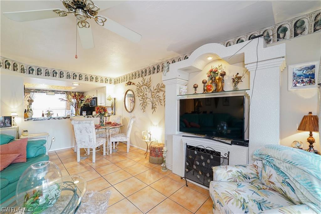 Living area with tile patterned floors and a ceiling fan