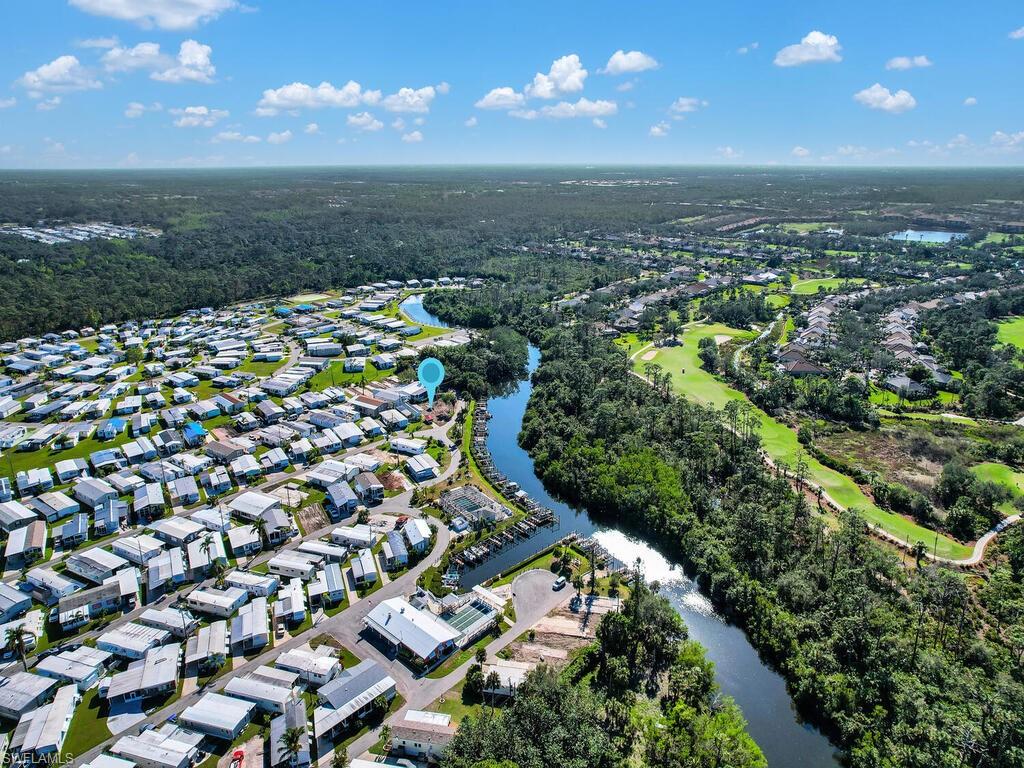 Aerial view of property and surrounding area featuring a nearby body of water and nearby suburban area