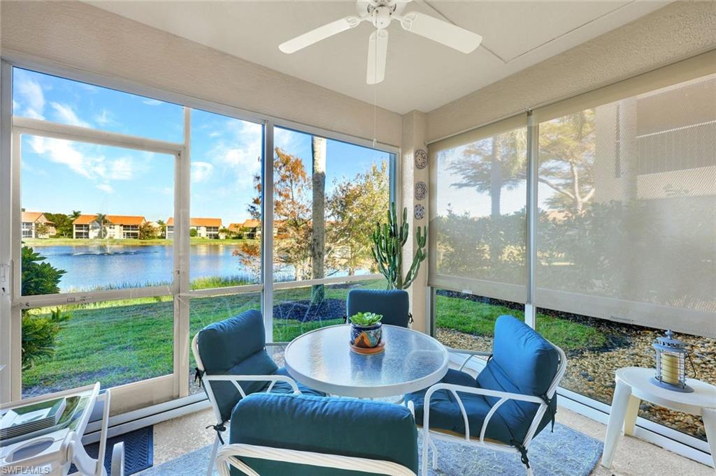 Screened in lanai with a water view, ceiling fan, and outdoor dining space