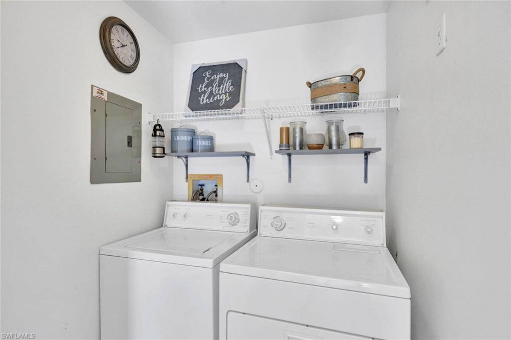 Cozy laundry room with electric panel and separate washer and dryer