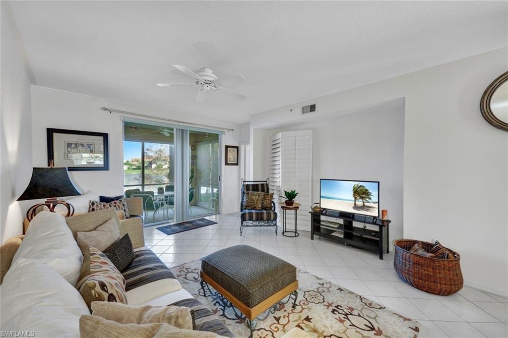 Living area featuring light tile patterned flooring and ceiling fan