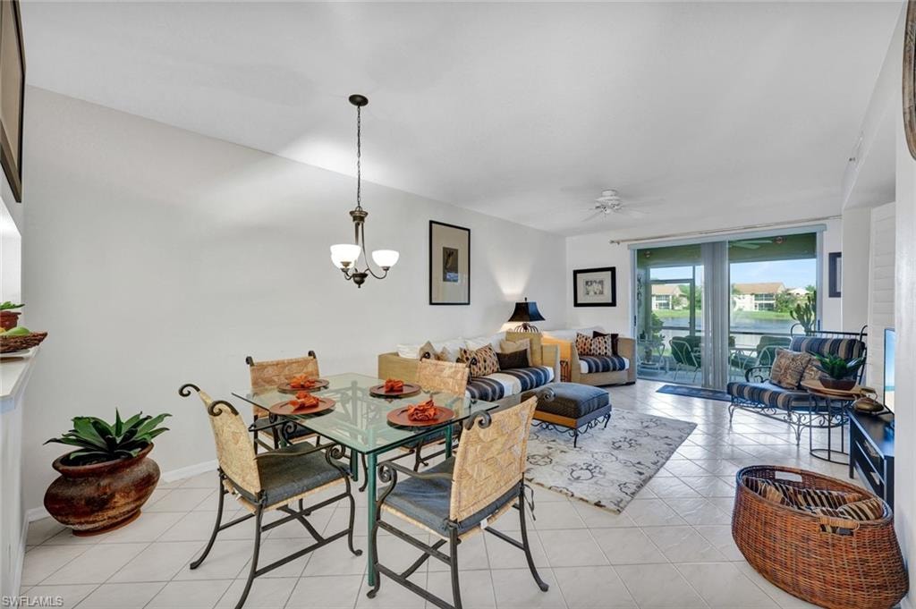 Dining room featuring light tile patterned floors, a ceiling fan, and a chandelier