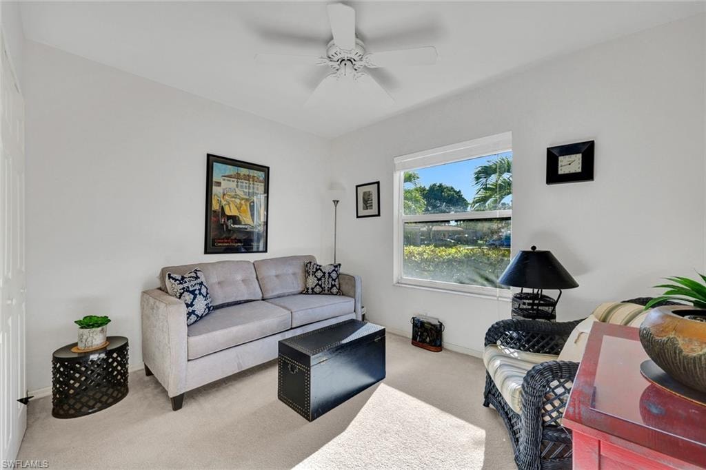 Secondary bedroom featuring a queen sized sleeper sofa, carpeted floors with ceiling fan and baseboards