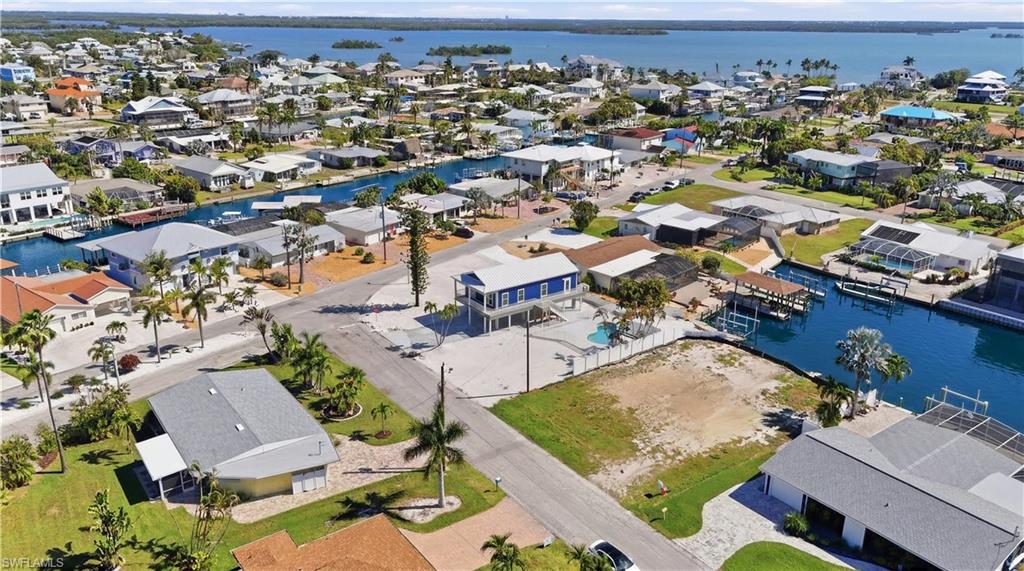 Aerial perspective showcasing a residential area with canal access, featuring numerous properties with private boat docks - Virtually Edited Image