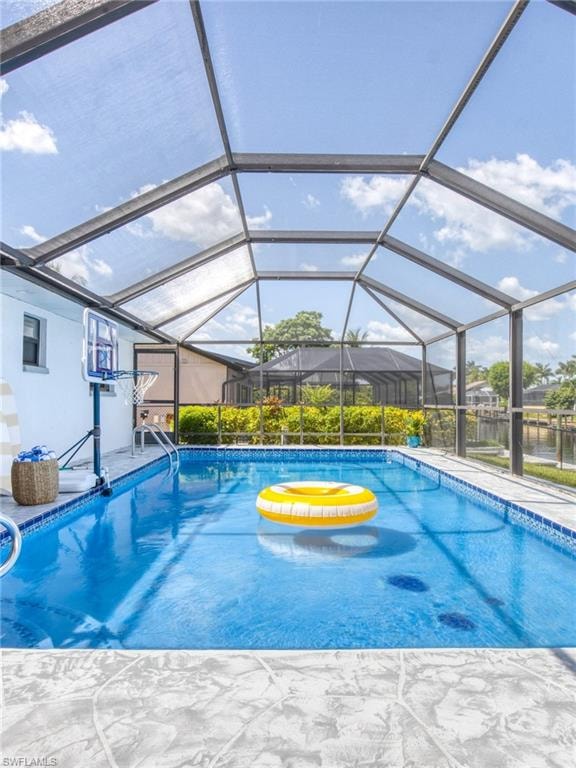 Outdoor pool with a sunroom, a lanai, and a patio