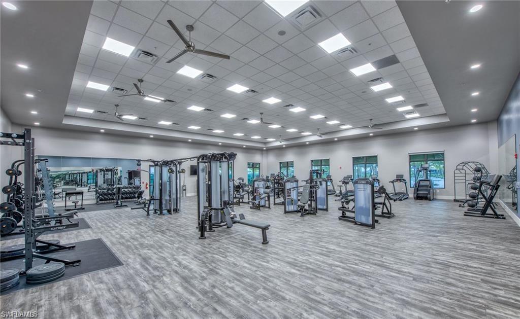 Workout area featuring a ceiling fan, a towering ceiling, and a paneled ceiling