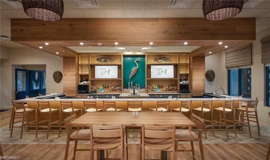 Indoor wet bar featuring open shelves, recessed lighting, and light countertops