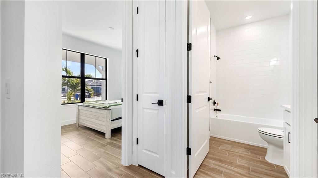Full bath featuring wood finish floors, shower / tub combination, vanity, and recessed lighting