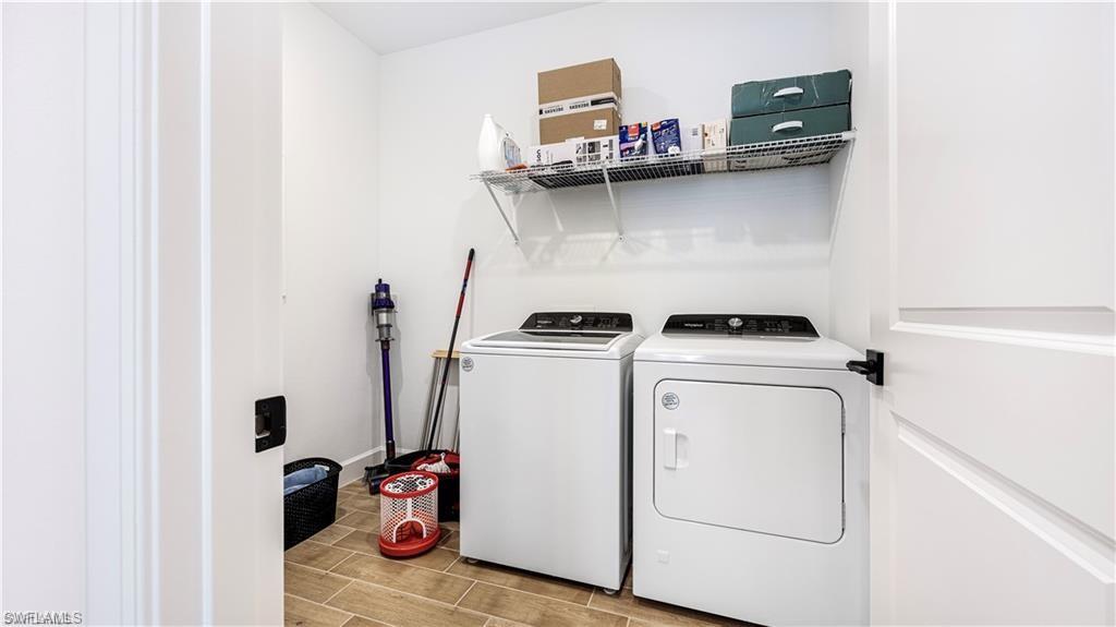 Washroom with wood tiled floors and independent washer and dryer