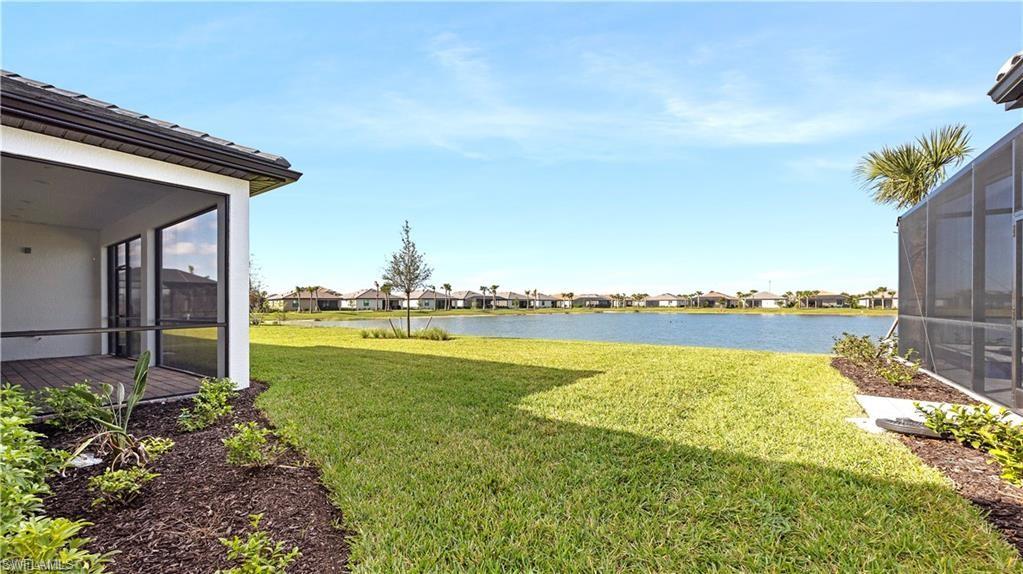 View of green lawn featuring a sunroom, a water view, a lanai, and a residential view
