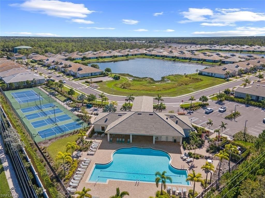 Aerial view of residential area featuring a pool and a large body of water