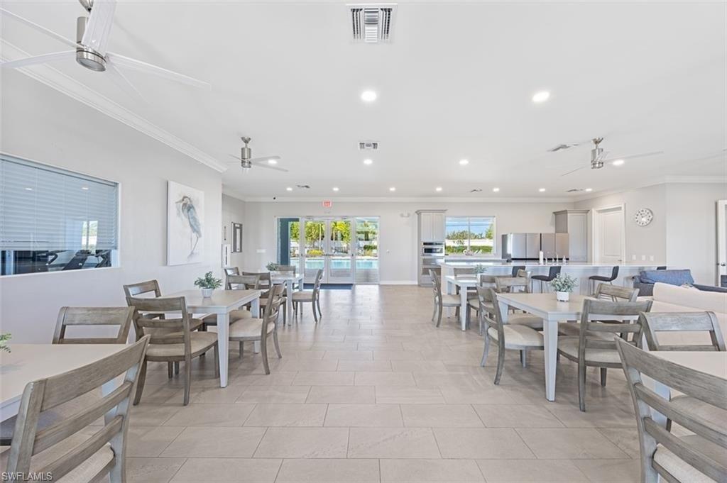 Dining space with ceiling fan, ornamental molding, and recessed lighting