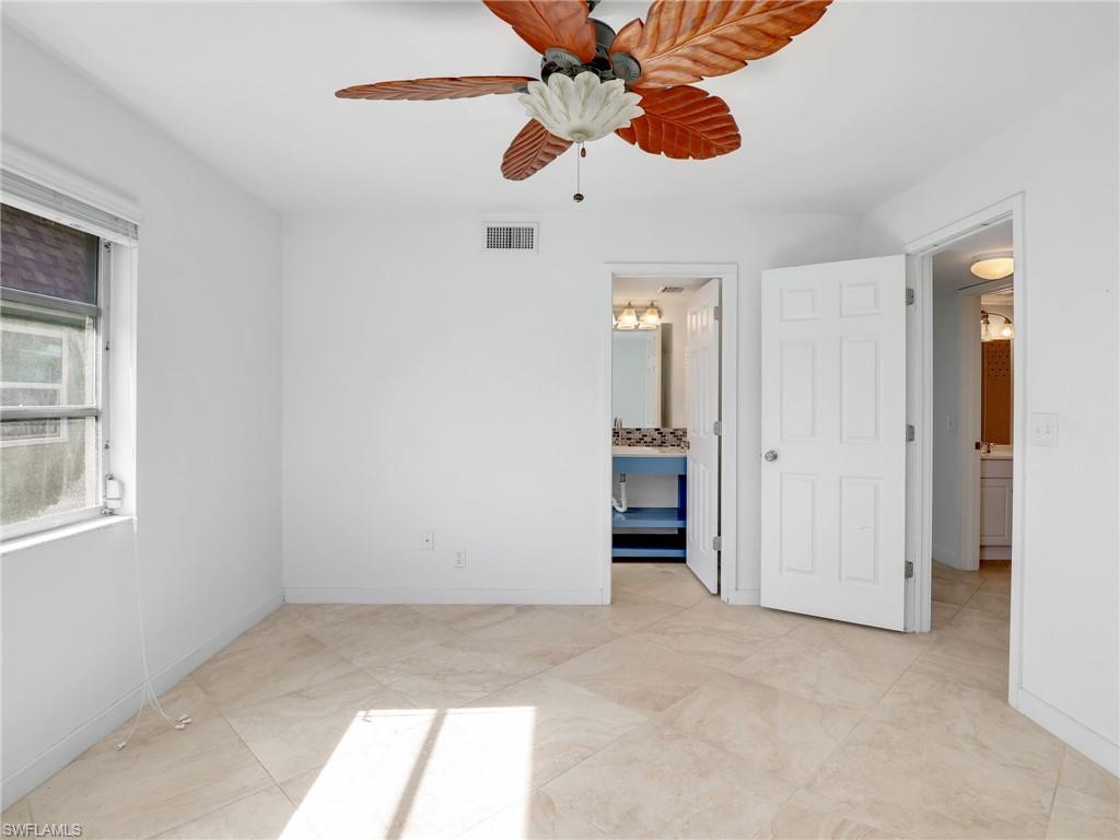 Unfurnished bedroom with a ceiling fan and ensuite bathroom