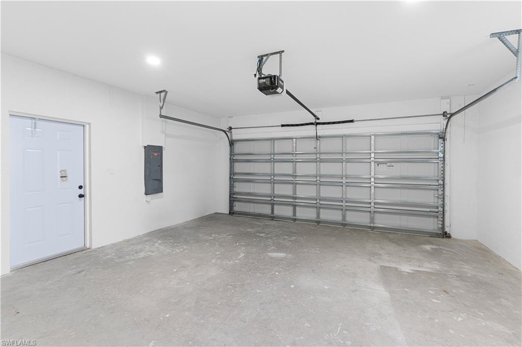 Garage featuring electric panel and a garage door opener