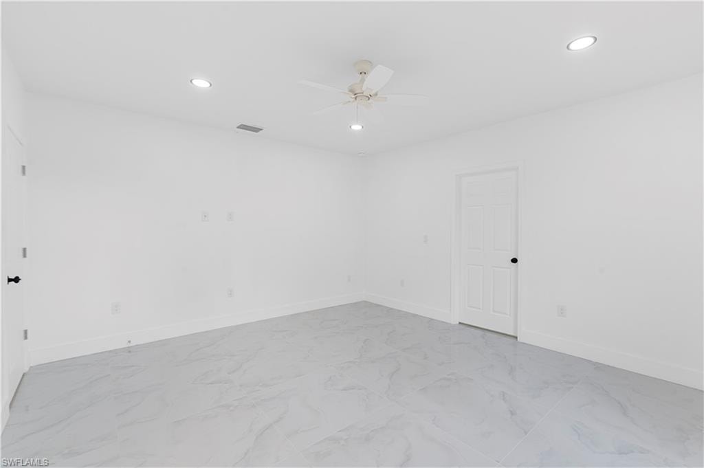 Empty room featuring recessed lighting, light marble finish flooring, and a ceiling fan
