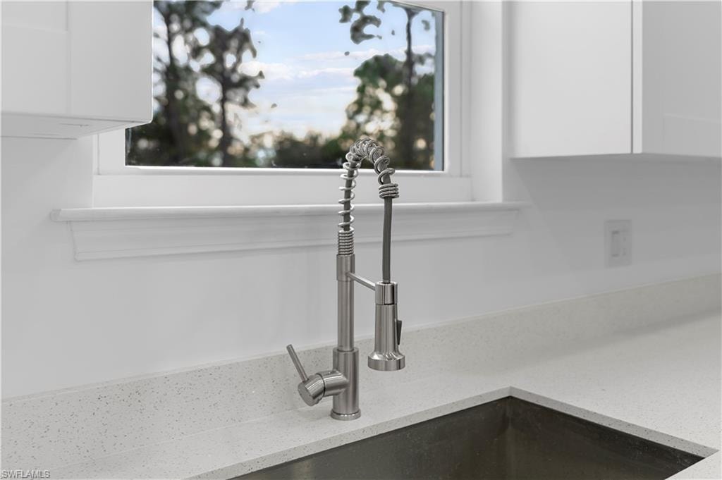Kitchen view of light stone countertops and white cabinetry