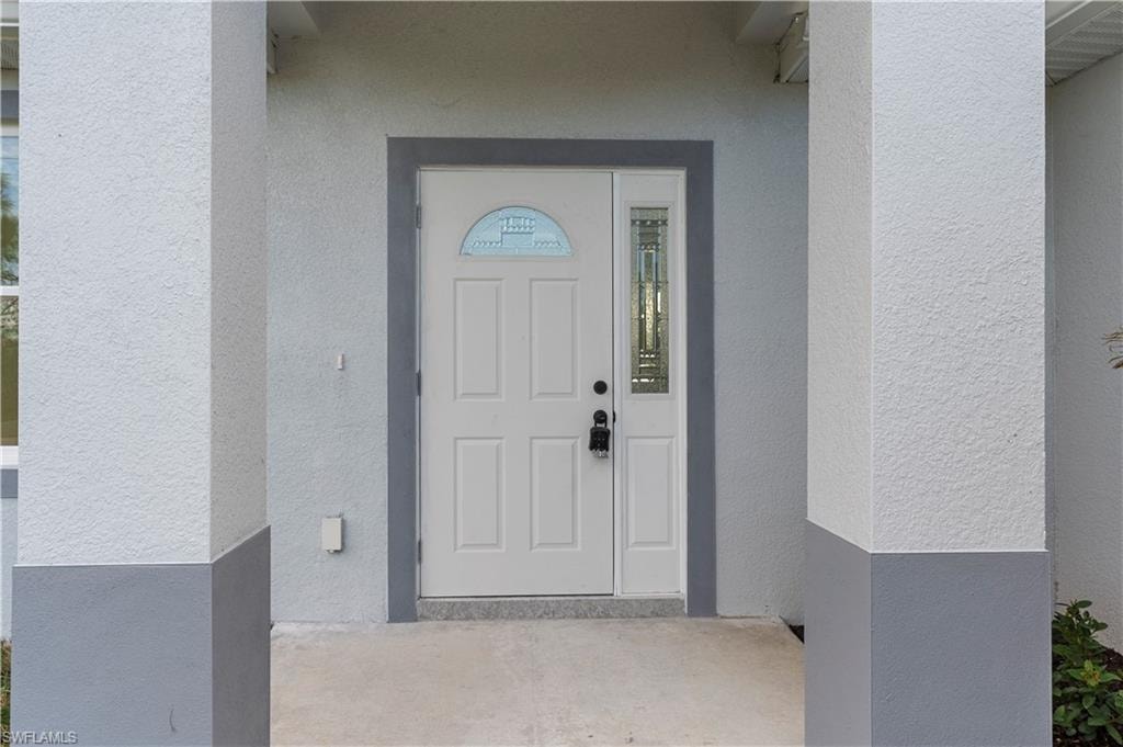 Property entrance featuring stucco siding