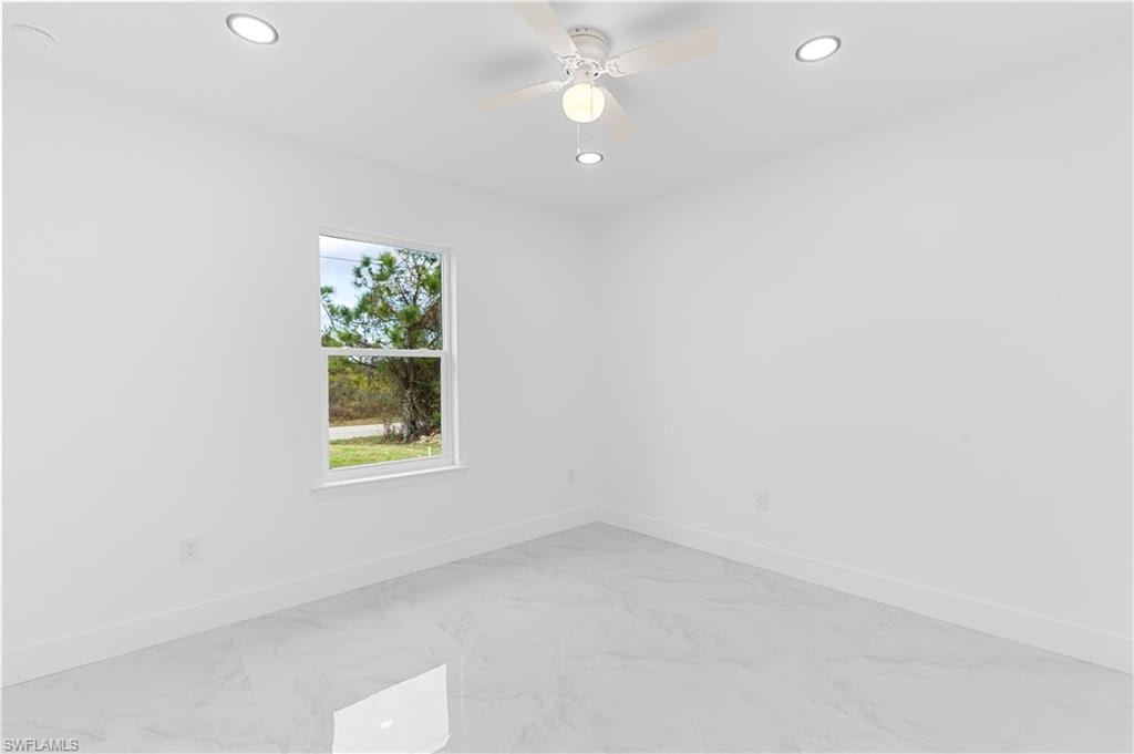 Unfurnished room with light marble finish flooring, ceiling fan, and recessed lighting