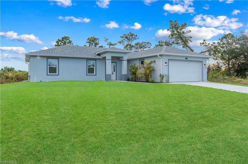 Ranch-style home with a front lawn, stucco siding, concrete driveway, an attached garage, and roof with shingles