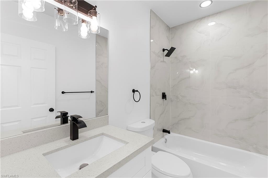 Bathroom with vanity, bathing tub / shower combination, and recessed lighting