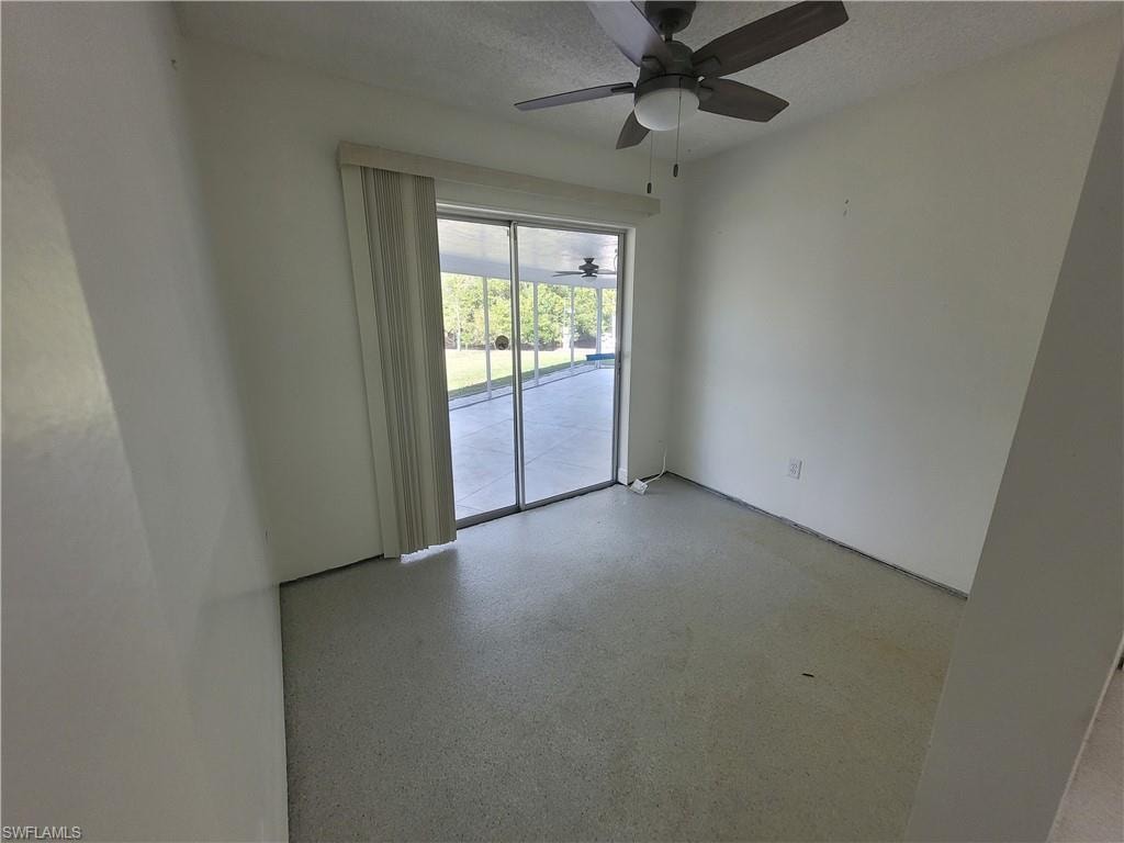 Empty room featuring a textured ceiling and speckled floor