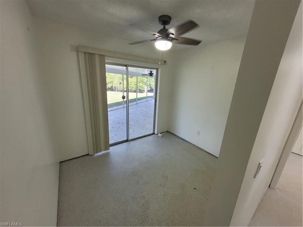 Unfurnished room featuring a ceiling fan and a textured ceiling