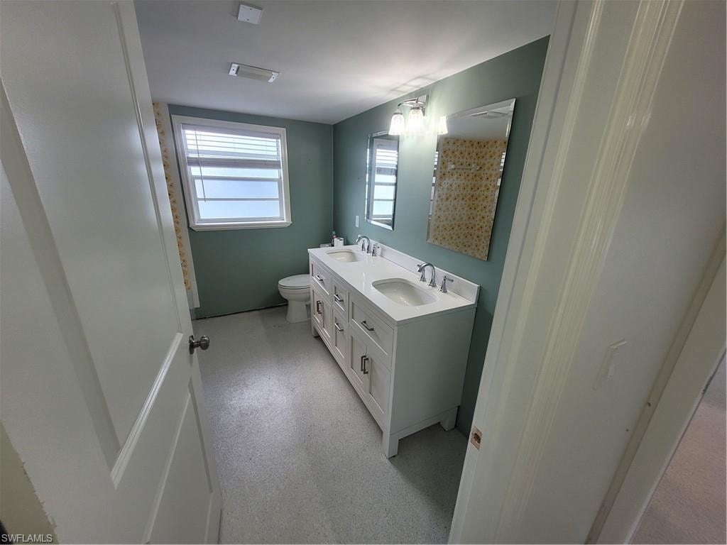 Bathroom featuring double vanity and toilet