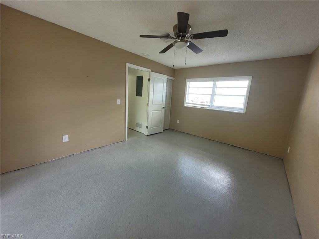Unfurnished bedroom featuring a ceiling fan and a textured ceiling