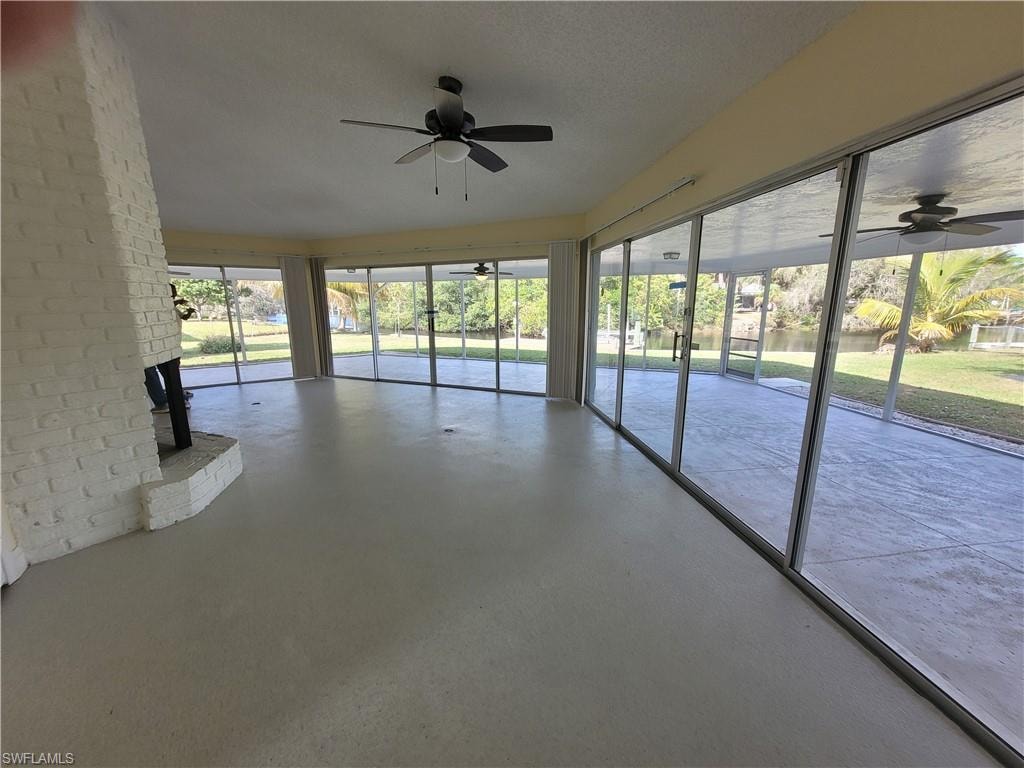 Unfurnished sunroom featuring ceiling fan
